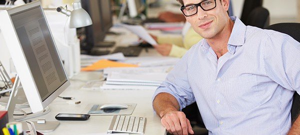 Man Working At Desk In Busy Creative Office