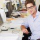 Man Working At Desk In Busy Creative Office